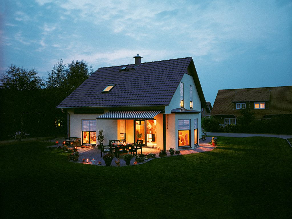 Haus in der Dämmerung mit Rollladen und Markise